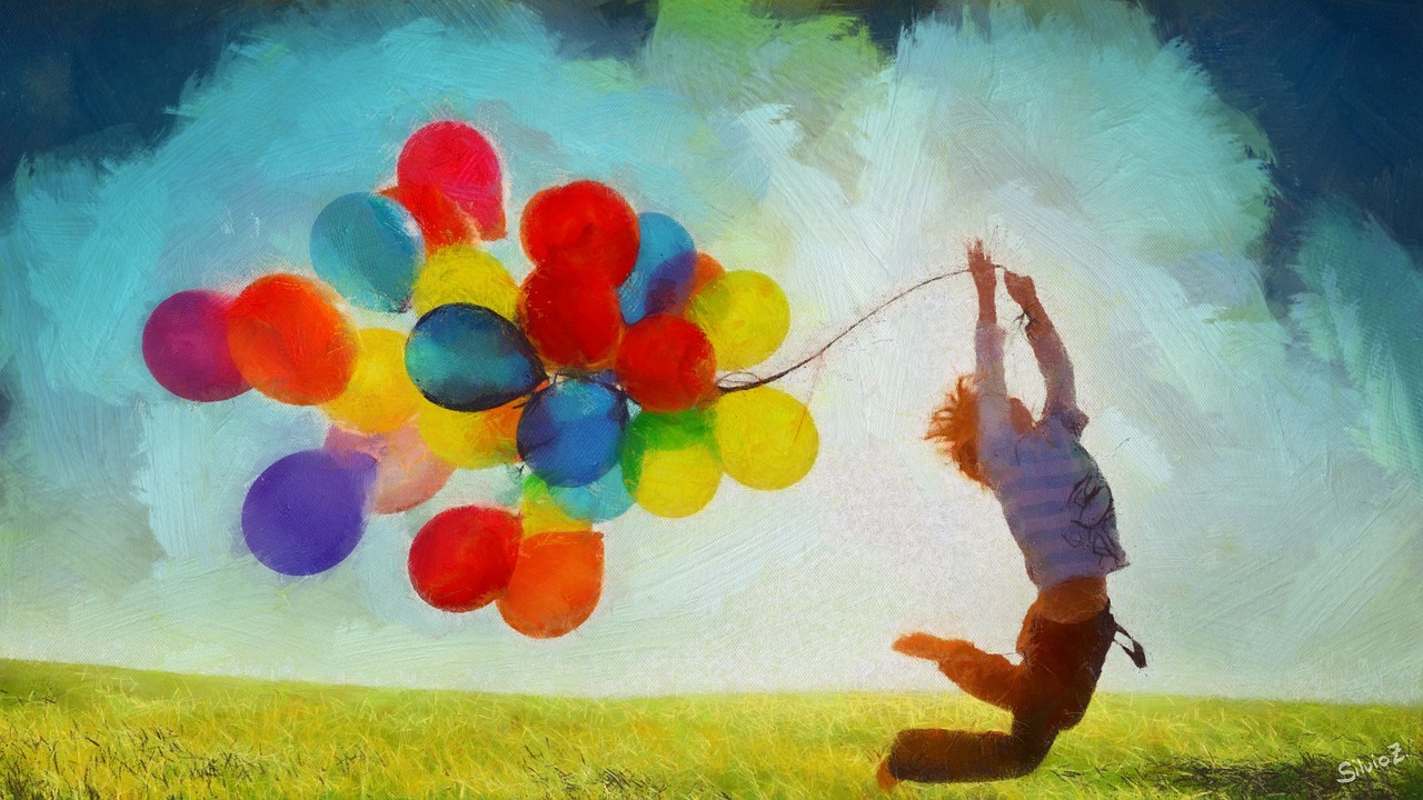 pojke som håller i ett knippe ballonger och lyfter mot skyarna.